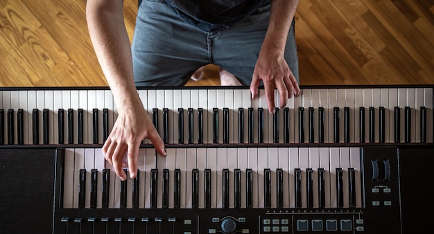 ピアノの鍵盤の上面図の男性の手