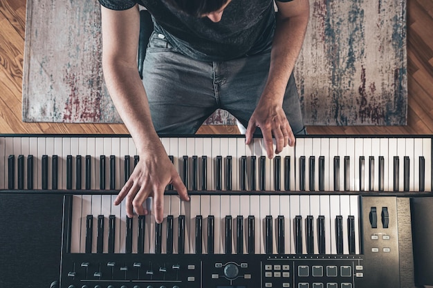 Male hands on the piano keys top view