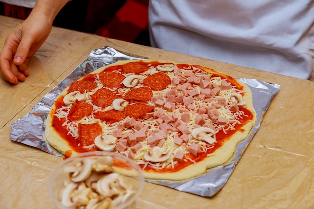 Male hands preparing dough for pizza on table closeup