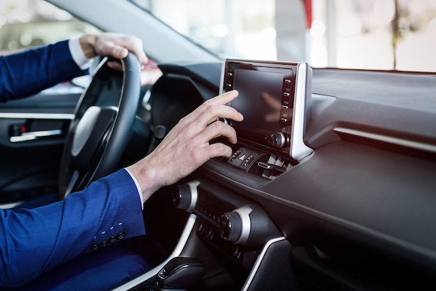 Male hands on steering wheel, car interior