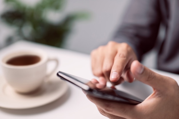 Male hands touching mobile phone Man using smartphone