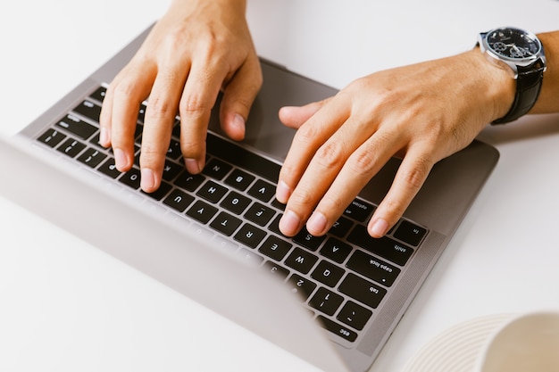 Male hands typing on keyboard, Man using laptop in home office