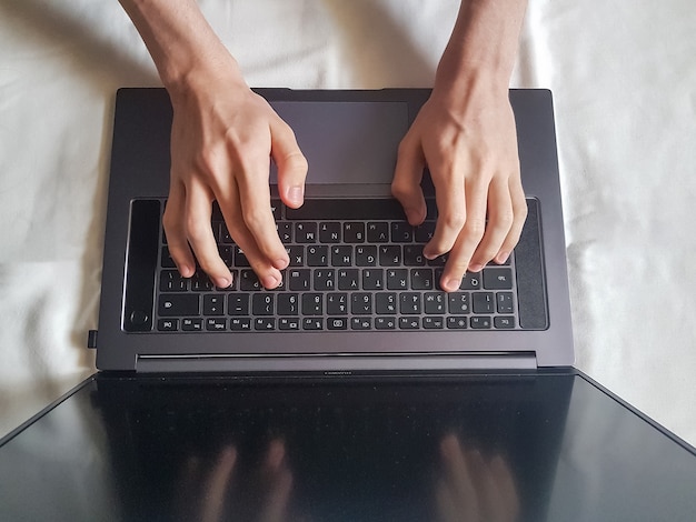 Male hands typing on laptop keyboard, working concept