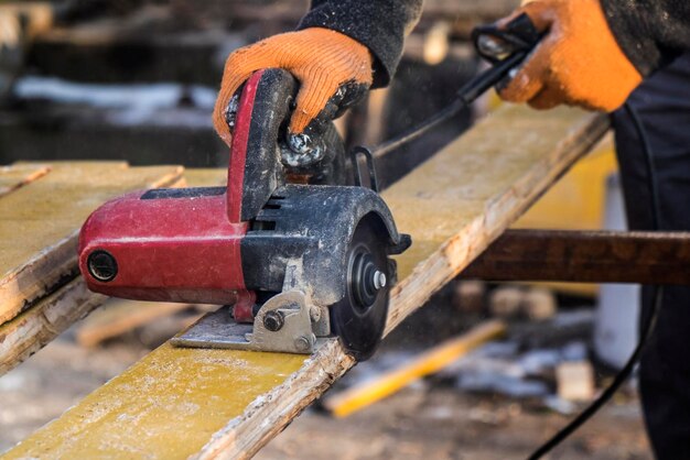 Male hands with circular saw while workimg with wood