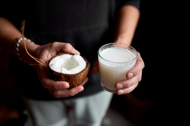 Male hands with glasse of vegan coconut milk Alternative types of nondairy milks plant milk made of various grain Clean eating Healthy dietxA