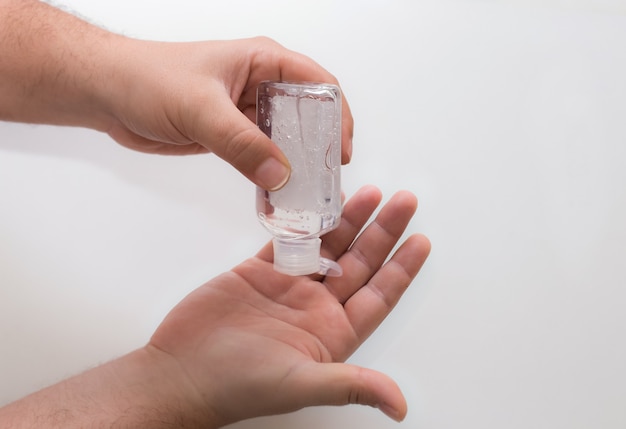 Male hands with hydroalcoholic gel on white background