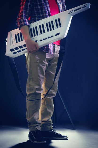 male hands with synthesizer on dark background