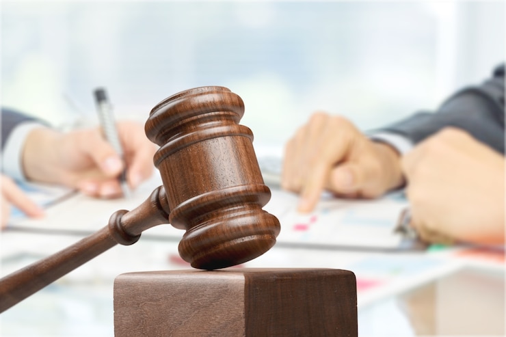 Photo male hands writing and wooden judge hammer on background