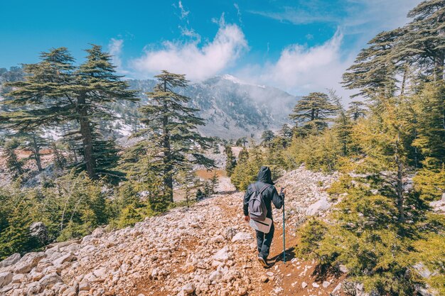 남성 등산객이나 등반가는 Tahtali Dag Turkey 근처의 Lycian 길에서 눈 덮인 봄 산의 전망을 감상합니다.