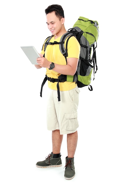 Male hiker with backpack using tablet computer