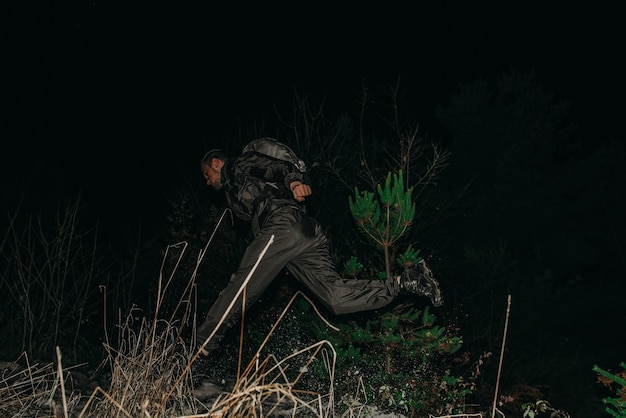 Male hikers in clothes for hiking and flashlights on winter mountain at night.