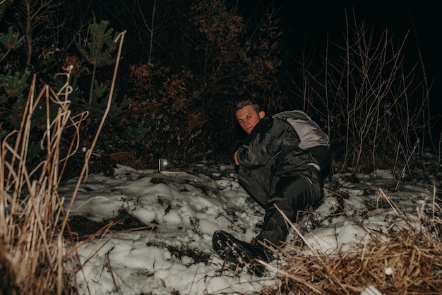 Male hikers in clothes for hiking and flashlights on winter mountain at night.