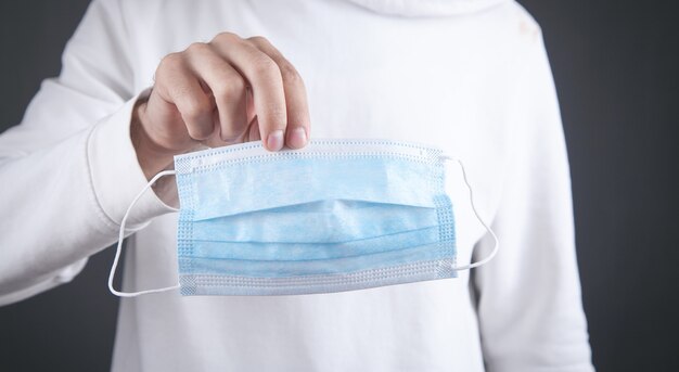 Photo male holding face mask. coronavirus. hygiene