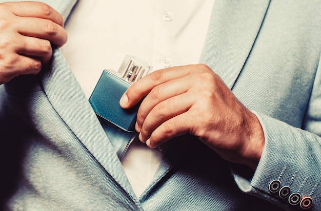 Male holding up bottle of perfume Perfume or cologne bottle and perfumery cosmetics male holding cologne