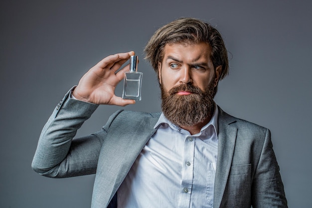 Male holding up bottle of perfume Perfume or cologne bottle and perfumery cosmetics scent cologne bottle male holding cologne Masculine perfume bearded man in a suit