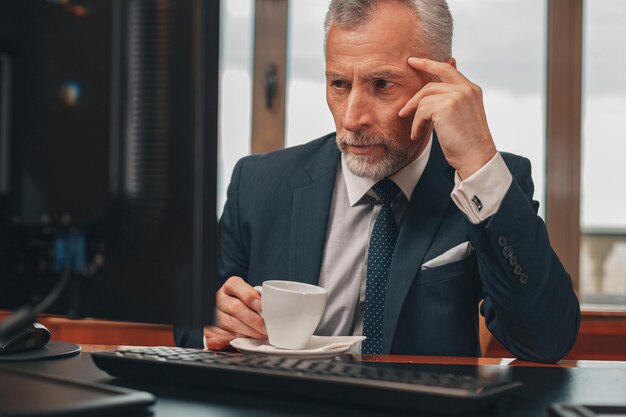 Male hotelier works at a computer while sitting in his office in a hotel