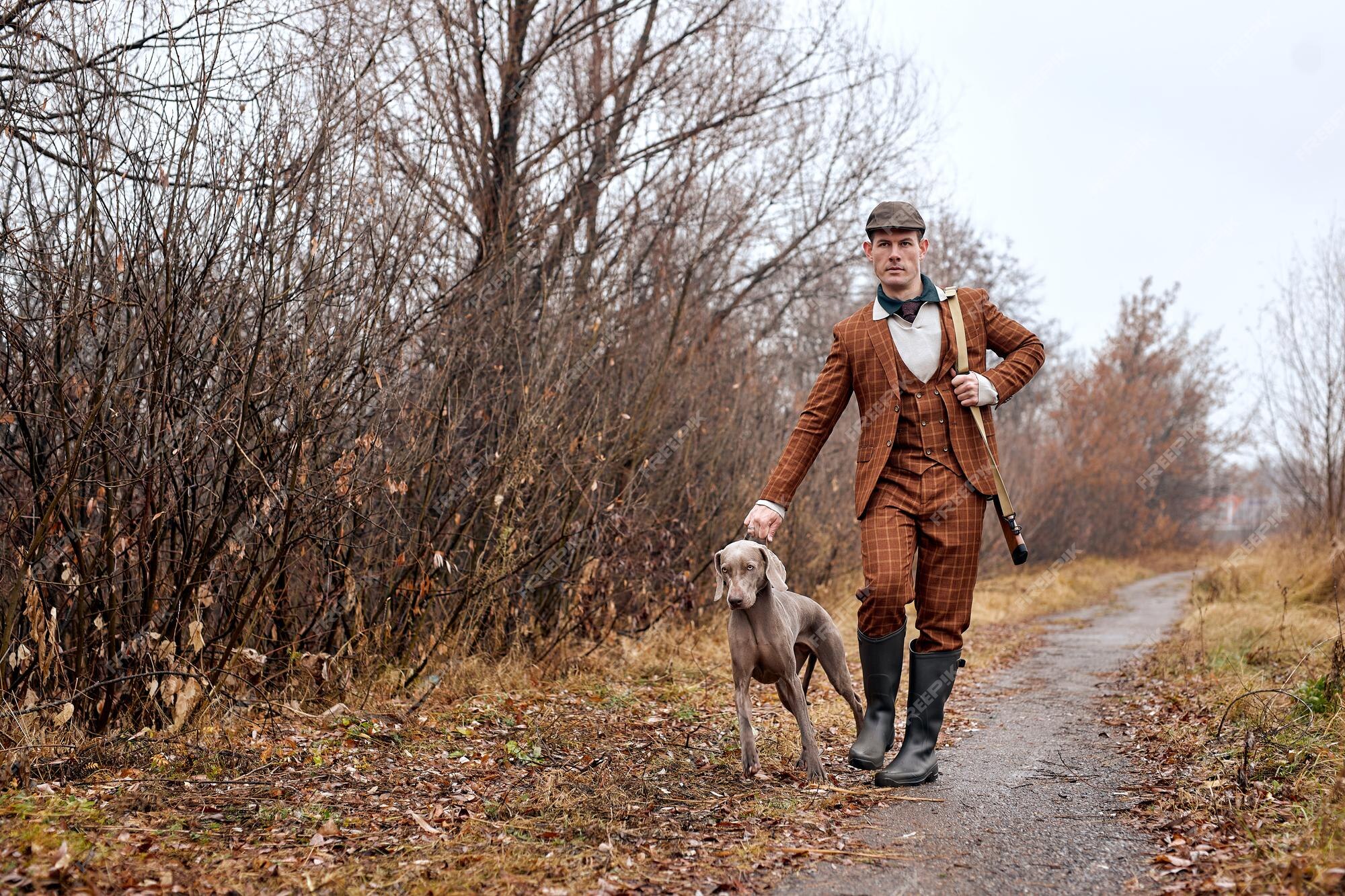 Premium Photo | Male hunter in suit ready to hunt, holding gun and