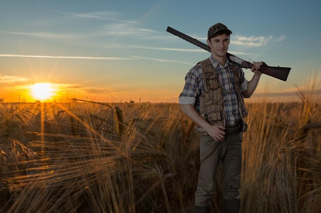 Photo male hunter with a rifle on a natural background