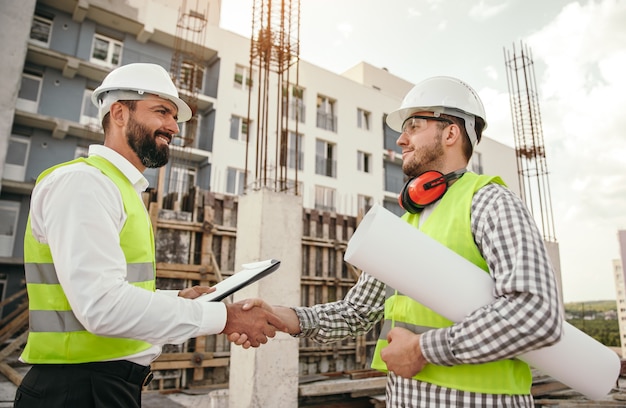 male inspector shaking hands and having meeting on construction site