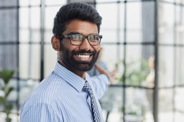 male investor beard looking at camera and smiling in modern office