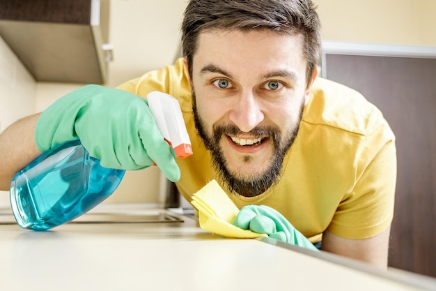 Male janitor cleaning kitchen with sponge