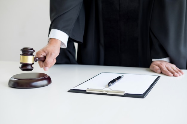 Male Judge lawyer In A Courtroom Striking The Gavel on sounding block