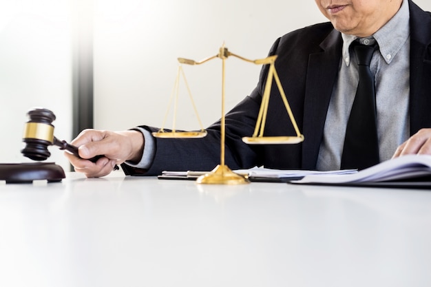 Male Judge lawyer In A Courtroom Striking The Gavel on sounding block