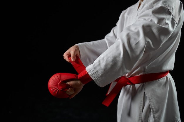 Combattente di karatè maschio in kimono bianco con cintura rossa e guanti, posizione di combattimento. karateka in allenamento, arti marziali, allenamento prima di combattere la competizione