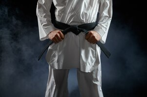 Foto karateka maschio, combattente con cintura nera, posizione di combattimento. uomo su allenamento di karate, arti marziali, allenamento prima di combattere la concorrenza