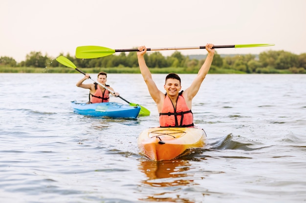 Kayaker maschio in kayak che celebra il suo successo