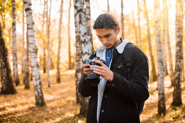 森の中で秋の写真を撮る男性の風景写真家