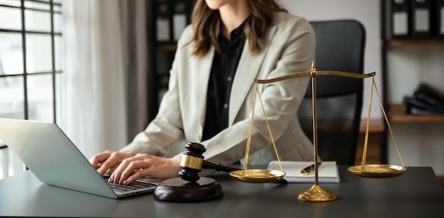 Male lawyer in the office with brass scale on wooden table justice and law concept in morning light