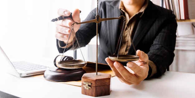 Адвокат-мужчина, работающий с контрактными документами и деревянным молотком на столе в зале суда, концепция правосудия и адвоката