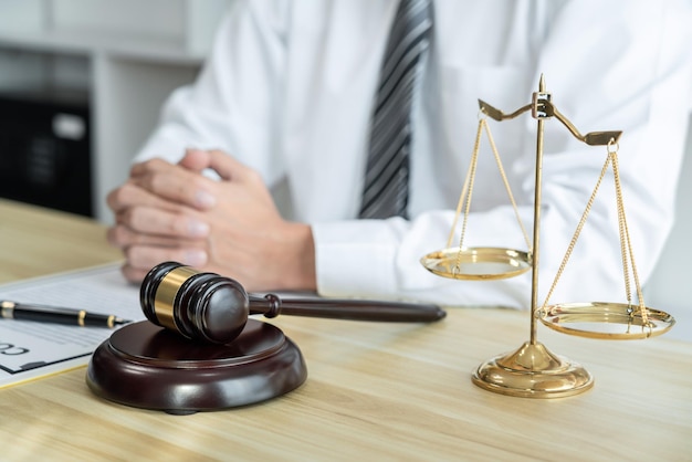 Male lawyer working with litigation contract paper documents of the estate lawsuit Law books and wooden gavel on table office