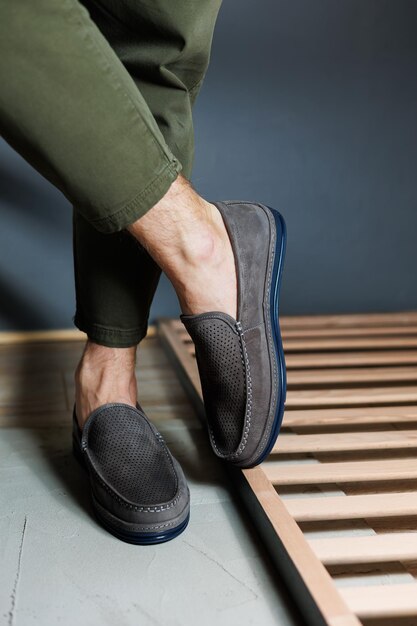 Male legs closeup in jeans and beige genuine leather moccasins