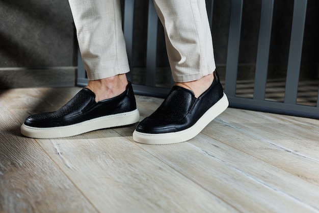 Male legs in leather shoes Comfortable men's black shoes without laces Casual men's moccasins