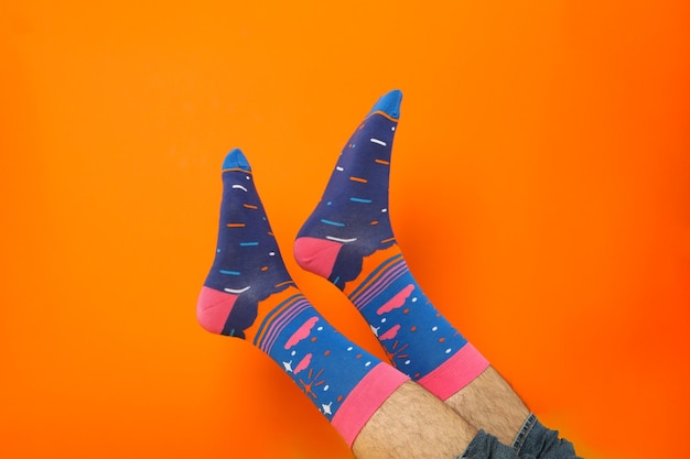 Male legs in socks on orange background