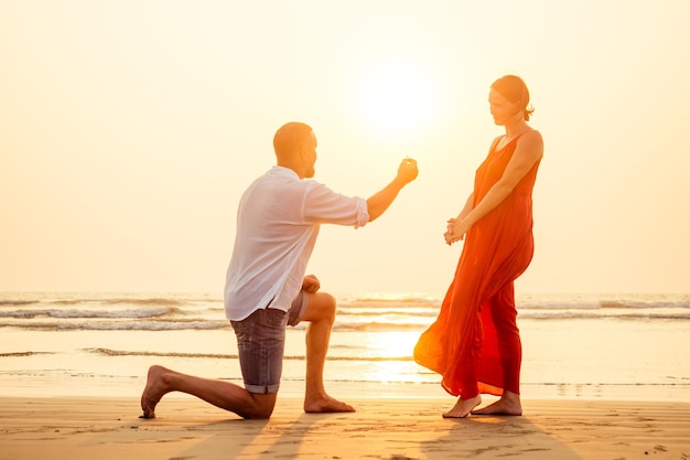 Male making proposal with engagement ring to his girlfriend at\
sea beachvalentine\'s day february 14 wedding conceptman on his knee\
making a marriage proposal to his woman sunset romantic i said\
yes