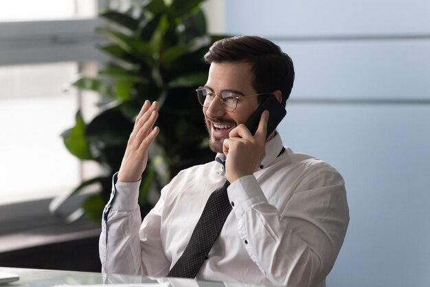 Male manager sit at desk use cellphone enjoy conversation solve\
help to client distantly telemarketer provides information explain\
products services prices answer questions from customers\
concept