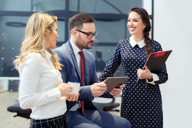 Male manager and two female employees are working together in a conference room