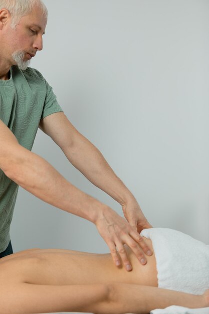 Male massage therapist doing massage to a woman