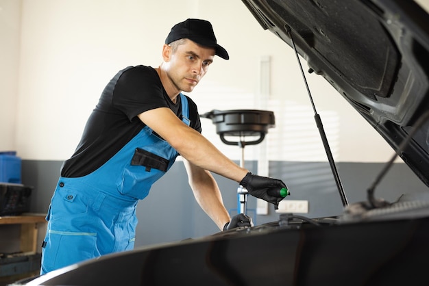 Male mechanic is working in car service hes using ratchet car\
mechanic using wrench to repair