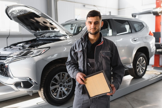 Male mechanic near car in service center