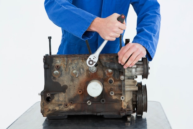 Male mechanic repairing car engine