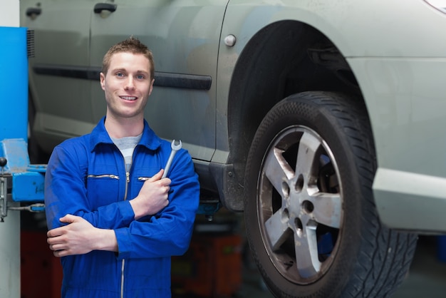 Male mechanic standing by car