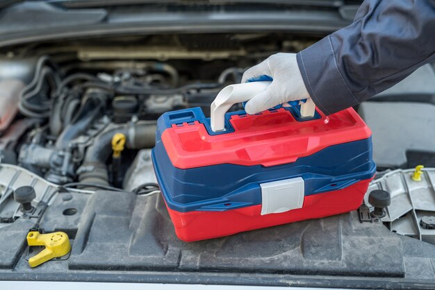 Male mechanic using wrench key checking engine of car. auto service