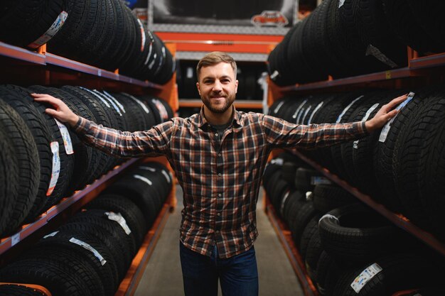 Photo male mechanic with car tires in automobile service center