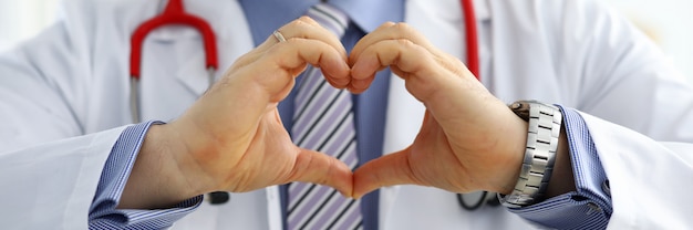 Foto mani maschii di medico della medicina che mostrano a forma di cuore