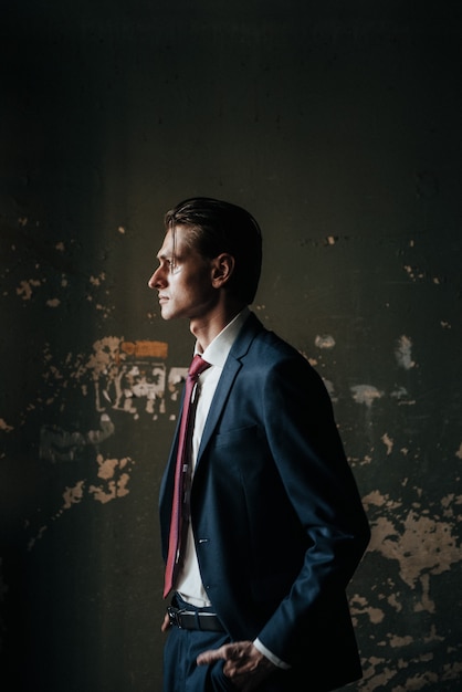 Male model in black suit and red tie poses for men's clothing advertising. shooting for men's clothing store