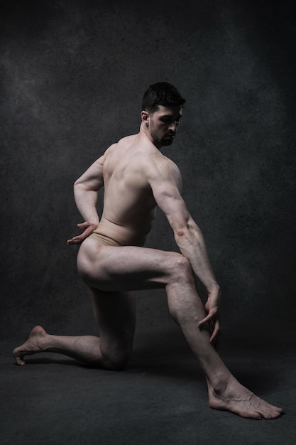 筋肉の強い体型で立っている男性ボディビルダーモデル